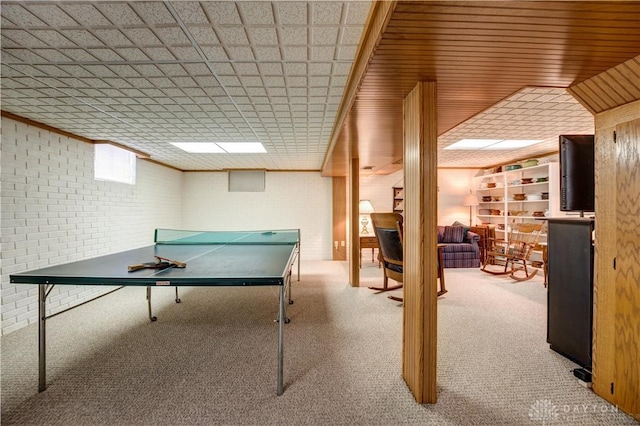 playroom with brick wall, carpet flooring, and crown molding