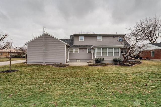 rear view of property featuring entry steps and a lawn