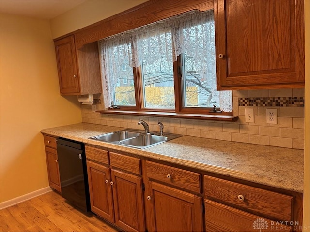 kitchen with a sink, decorative backsplash, light wood-type flooring, and dishwasher