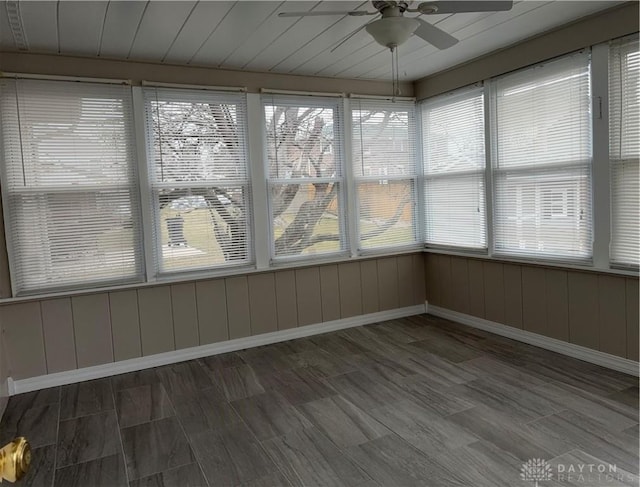 unfurnished sunroom featuring ceiling fan