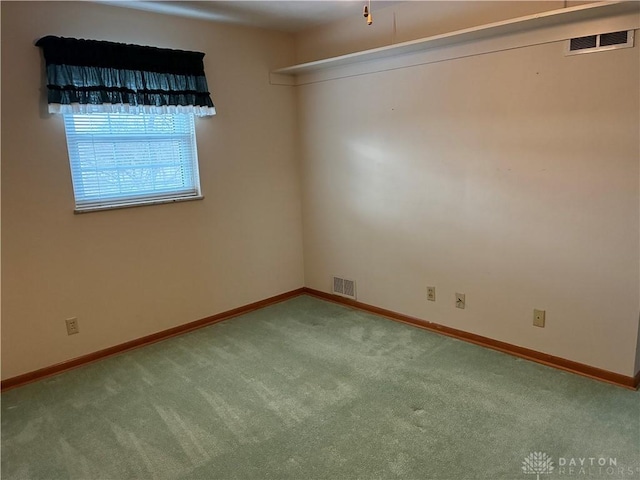 carpeted empty room with visible vents and baseboards