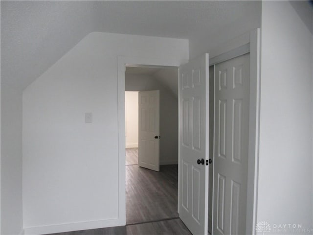 bonus room featuring dark wood-style floors and vaulted ceiling