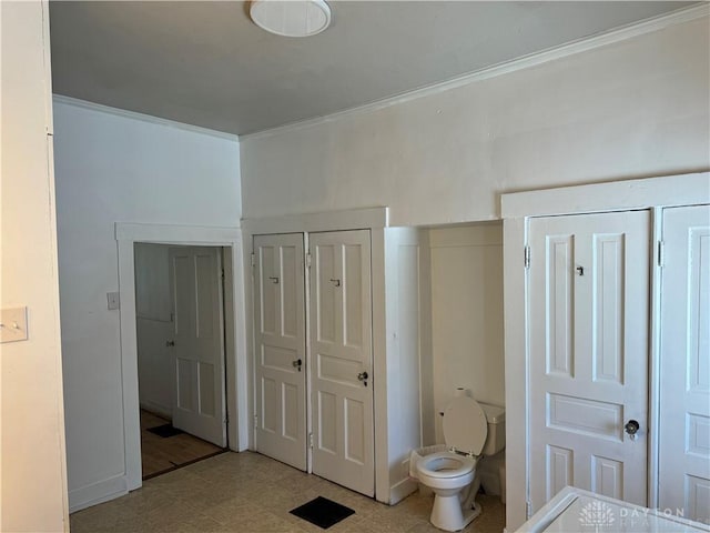 bathroom featuring toilet, ornamental molding, and tile patterned floors