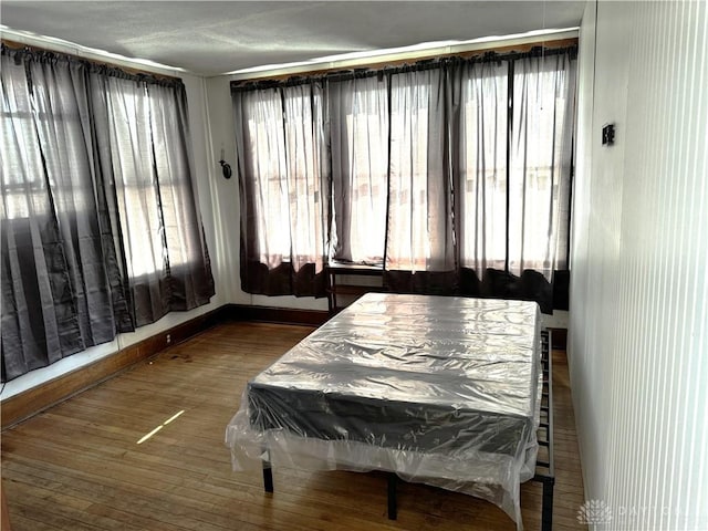 bedroom with baseboards and wood finished floors