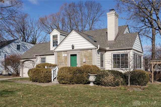 cape cod home with a garage, a chimney, and a front lawn