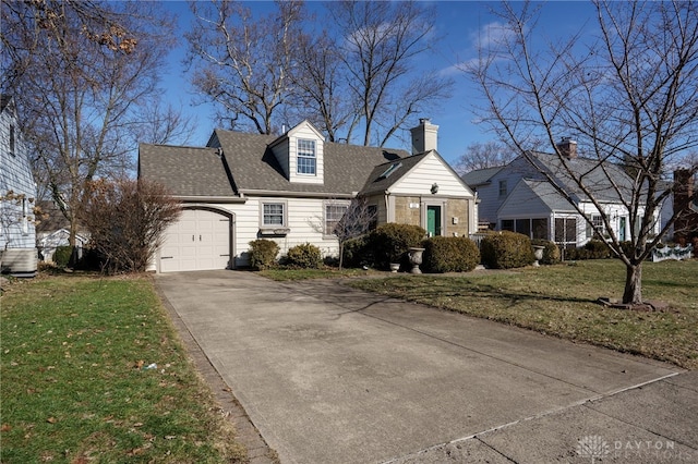 cape cod-style house featuring an attached garage, driveway, and a front lawn