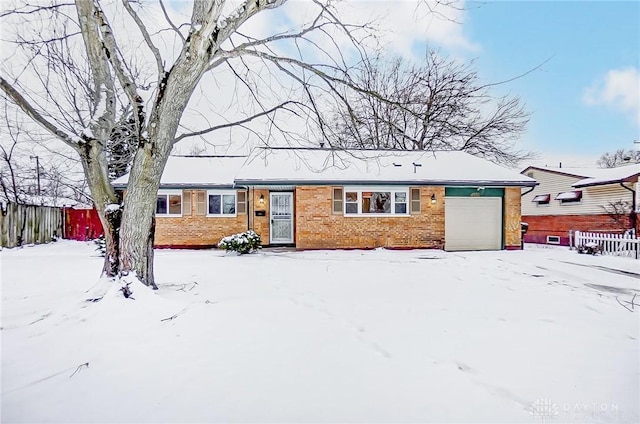 single story home with brick siding, an attached garage, and fence