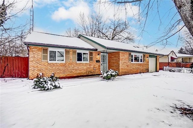 ranch-style house with a garage, brick siding, and fence