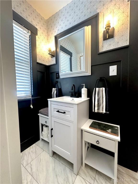 bathroom featuring marble finish floor, wallpapered walls, and vanity