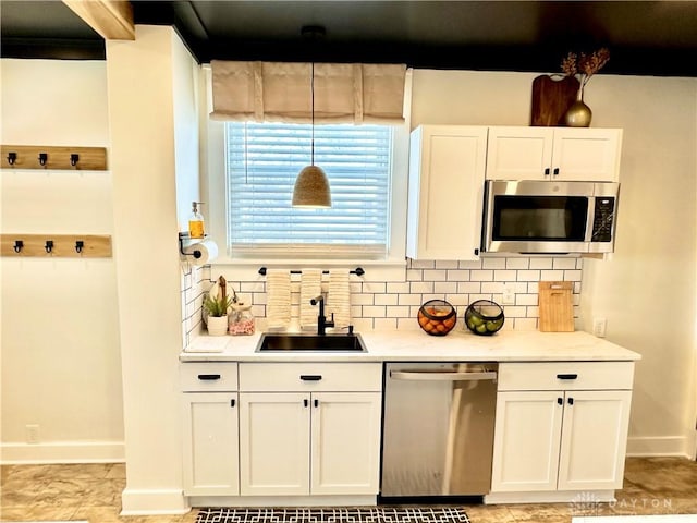 kitchen featuring backsplash, a sink, white cabinetry, and appliances with stainless steel finishes