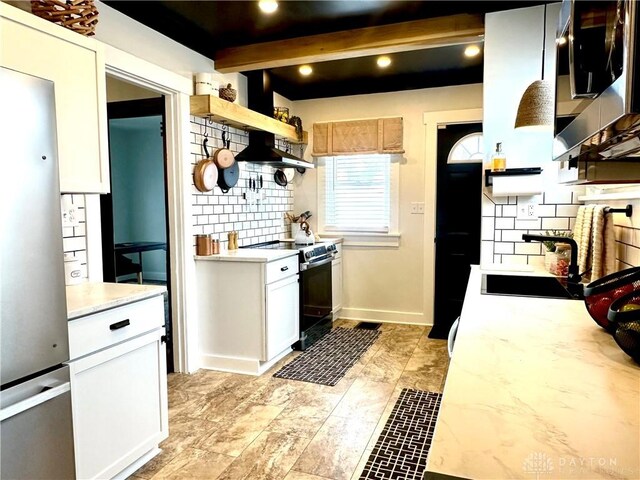 kitchen featuring light countertops, beam ceiling, appliances with stainless steel finishes, a sink, and open shelves