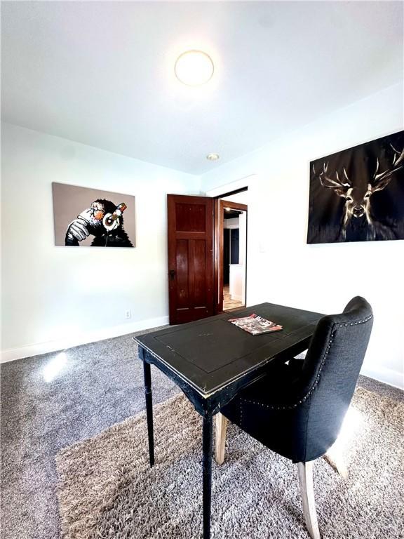 carpeted office featuring baseboards