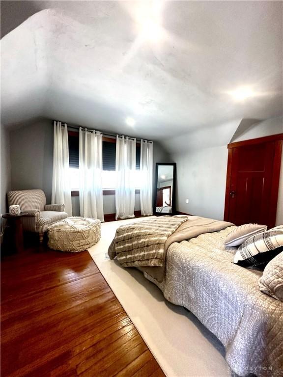 bedroom with hardwood / wood-style flooring and vaulted ceiling
