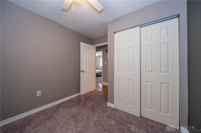 unfurnished bedroom with baseboards, carpet flooring, ceiling fan, and a closet