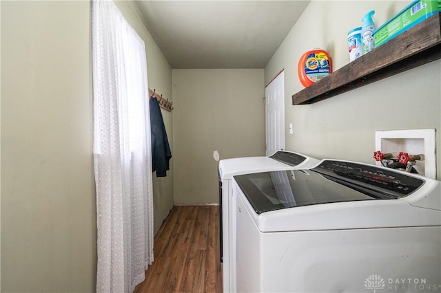 laundry room with washer and dryer, wood finished floors, and laundry area