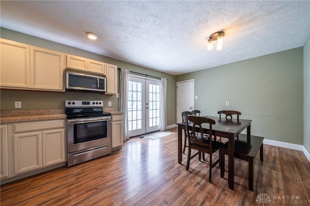 kitchen with light countertops, french doors, stainless steel appliances, baseboards, and dark wood finished floors