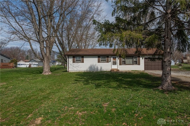 single story home featuring a front yard, an attached garage, dirt driveway, and entry steps