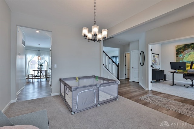 interior space with baseboards, visible vents, wood finished floors, carpet floors, and a chandelier