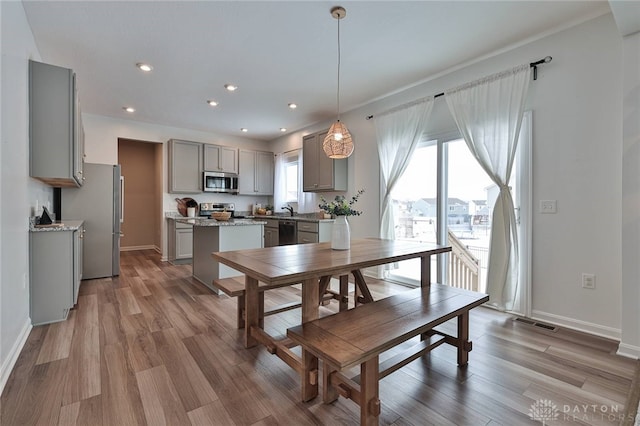 dining space featuring baseboards, visible vents, wood finished floors, and recessed lighting