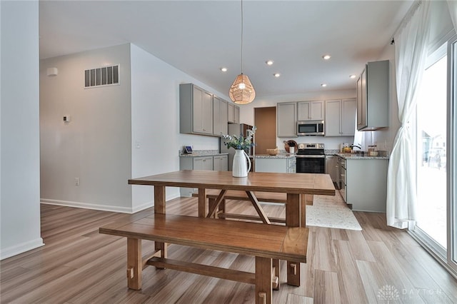 dining space featuring baseboards, recessed lighting, visible vents, and light wood-style floors