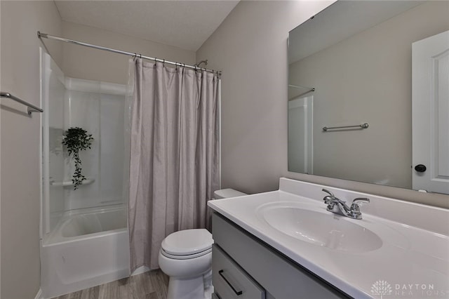 bathroom with toilet, wood finished floors, shower / bath combination with curtain, and vanity