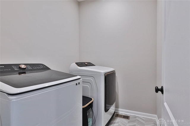 washroom featuring laundry area, washer and clothes dryer, and baseboards