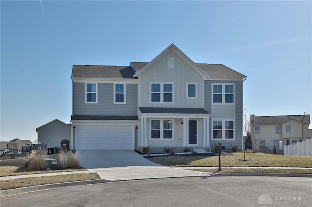 traditional-style house with an attached garage, board and batten siding, driveway, and fence