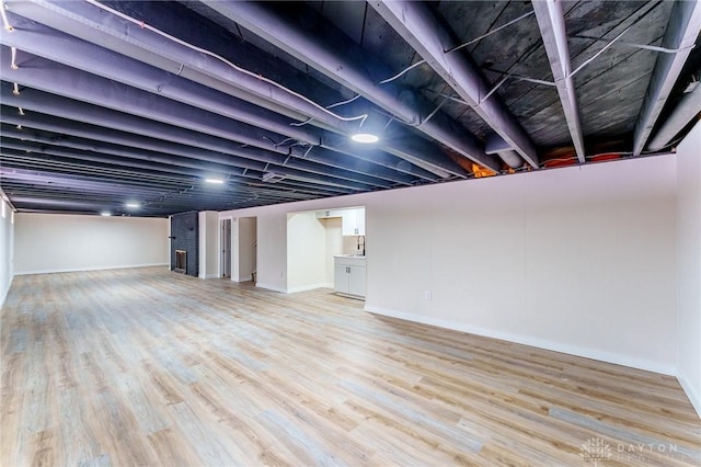 finished below grade area featuring light wood-style flooring and baseboards