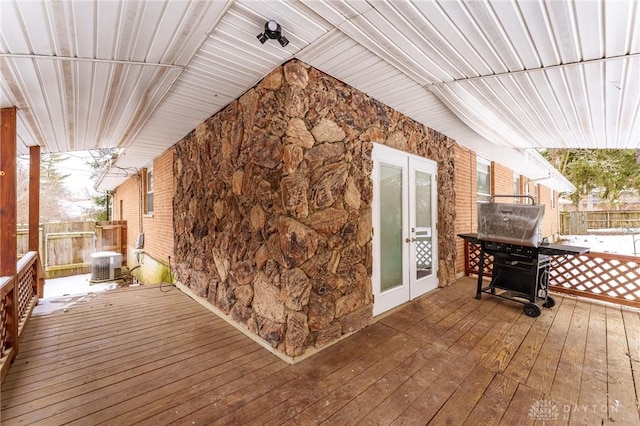 wooden terrace featuring french doors, fence, and central AC unit