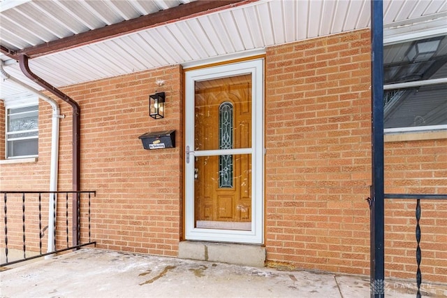 doorway to property with brick siding