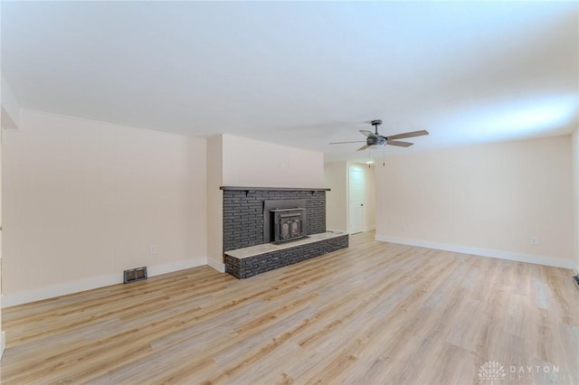 unfurnished living room featuring ceiling fan, visible vents, light wood-style flooring, and baseboards