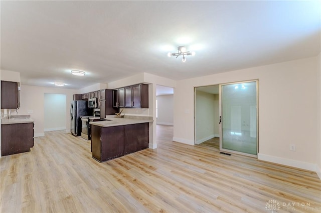 kitchen featuring visible vents, appliances with stainless steel finishes, light countertops, dark brown cabinets, and light wood-type flooring