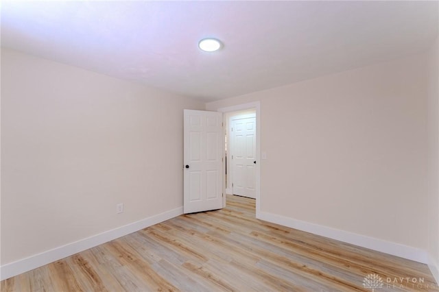 unfurnished room with light wood-style floors and baseboards