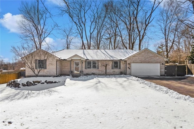 ranch-style house with driveway, brick siding, an attached garage, and fence