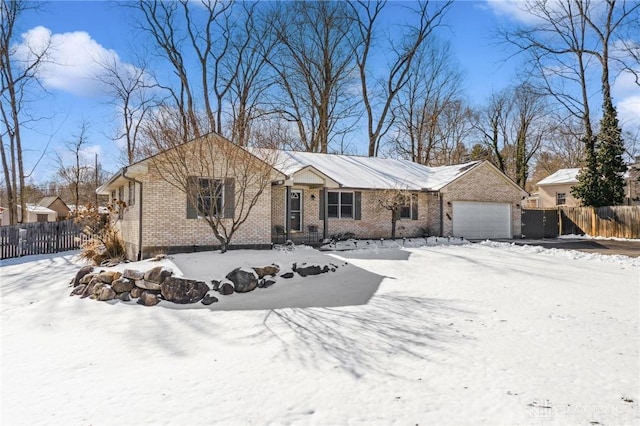 ranch-style house with brick siding, fence, and an attached garage