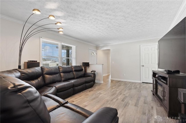 living room featuring light wood-style floors, baseboards, ornamental molding, and a textured ceiling