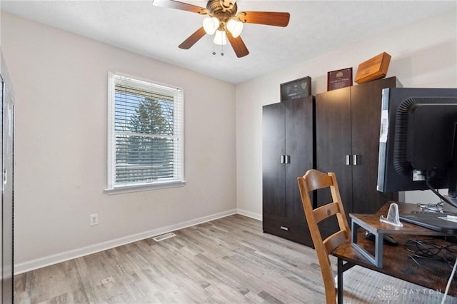 office space featuring light wood-style floors, ceiling fan, visible vents, and baseboards