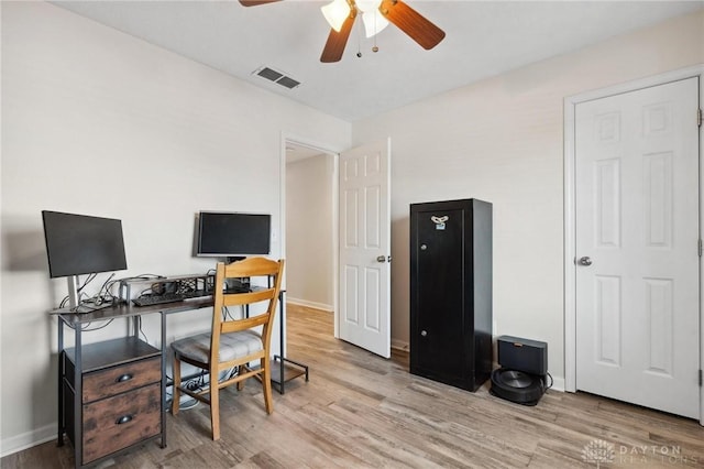 office space featuring light wood finished floors, baseboards, visible vents, and a ceiling fan