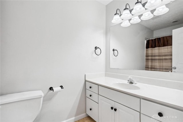 full bath with baseboards, vanity, and toilet