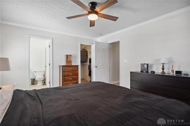 bedroom with visible vents, connected bathroom, ceiling fan, a spacious closet, and crown molding