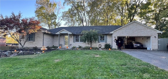 single story home featuring driveway, brick siding, a garage, and a front yard