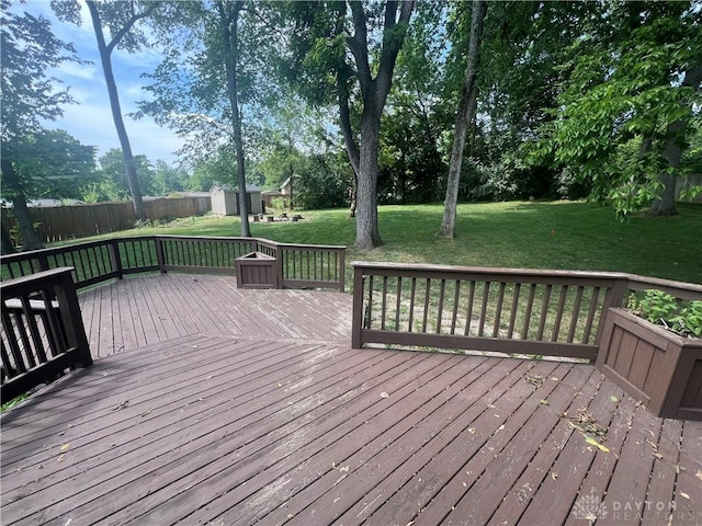 wooden deck with a lawn and fence