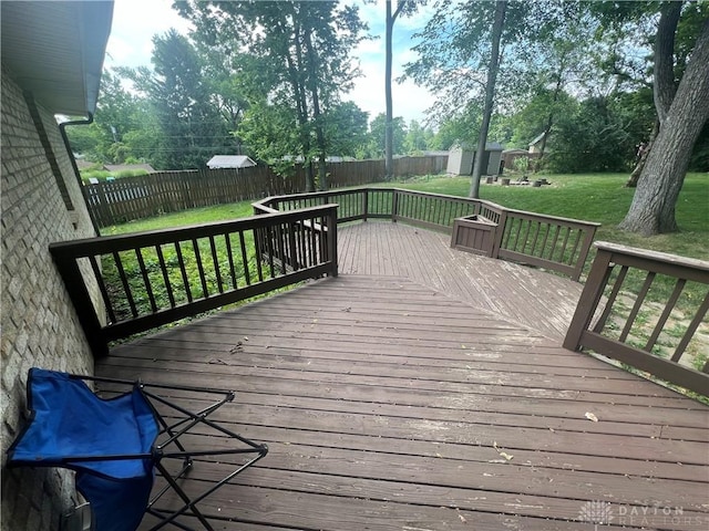 wooden terrace featuring a fenced backyard and a yard