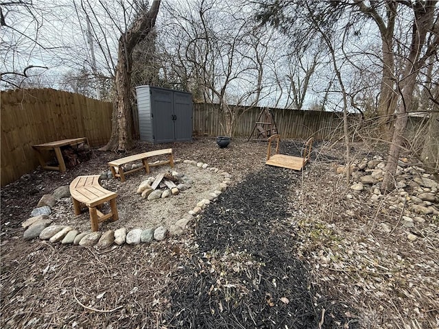 view of yard with a fenced backyard, an outdoor structure, and a shed