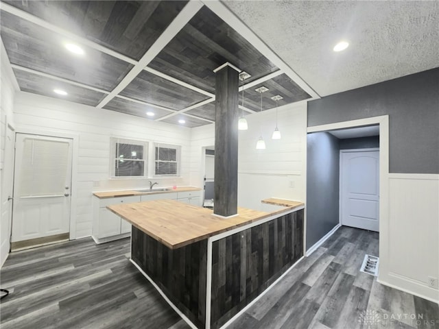 kitchen featuring hanging light fixtures, dark wood-style floors, butcher block countertops, and a sink