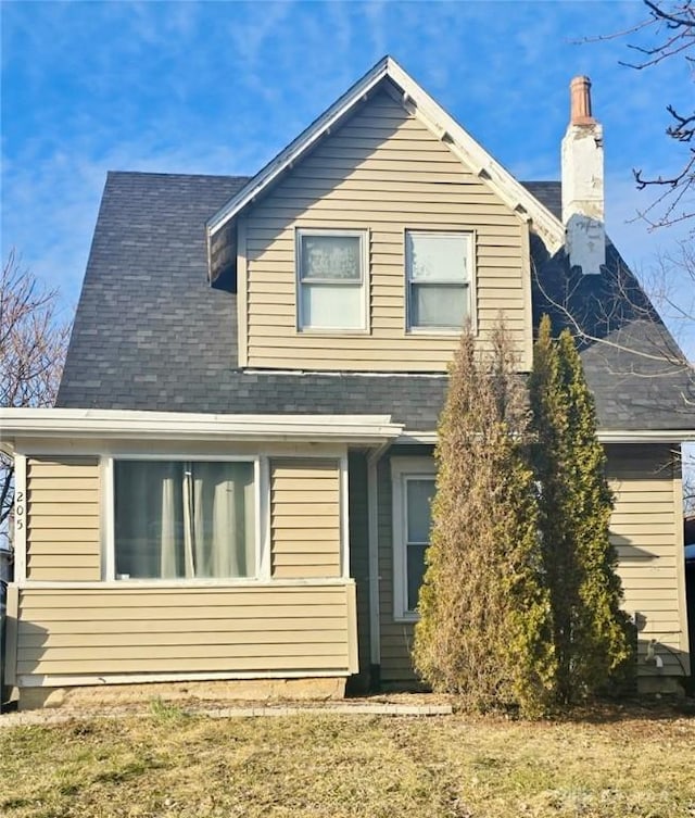 exterior space featuring a chimney and a shingled roof