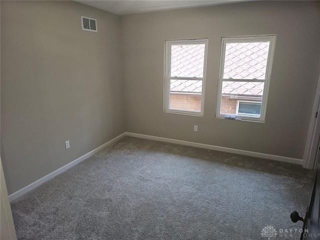 unfurnished room with baseboards, visible vents, and carpet flooring