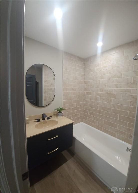 full bathroom with bathtub / shower combination, wood finished floors, and vanity