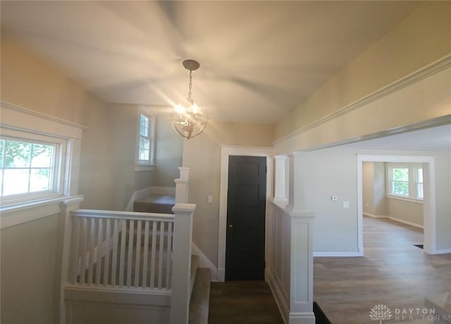 interior space featuring a notable chandelier, baseboards, and wood finished floors