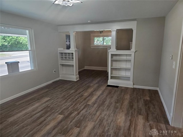 spare room with baseboards and dark wood finished floors